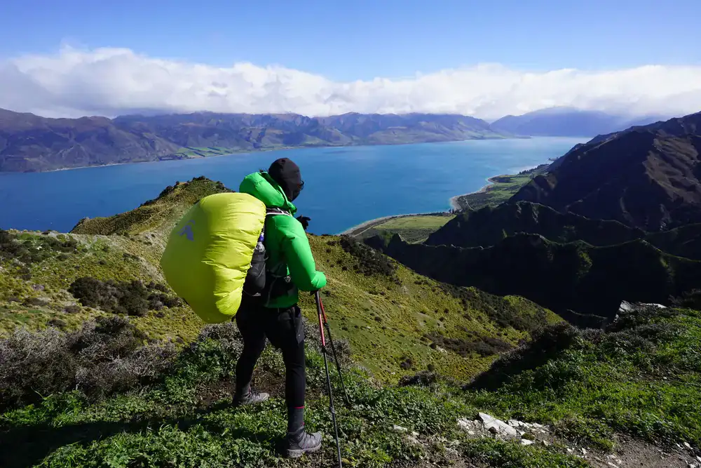 Hiker organizing gear at a scenic mountain overlook