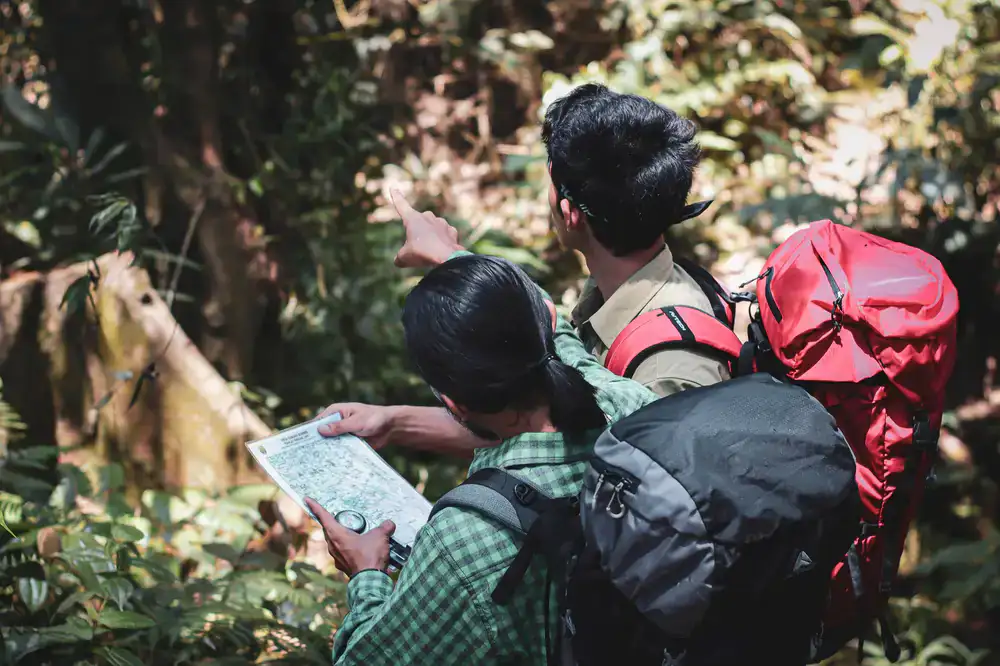 A private guide pointing out a route feature to a solo hiker on a steep trail