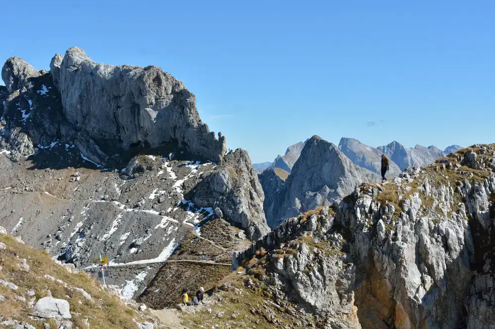 Hikers traversing a high alpine pass surrounded by dramatic peaks